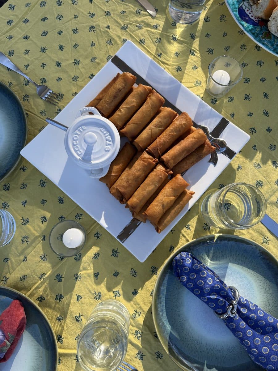 Crisp egg rolls plated with a dipping sauce on a set table