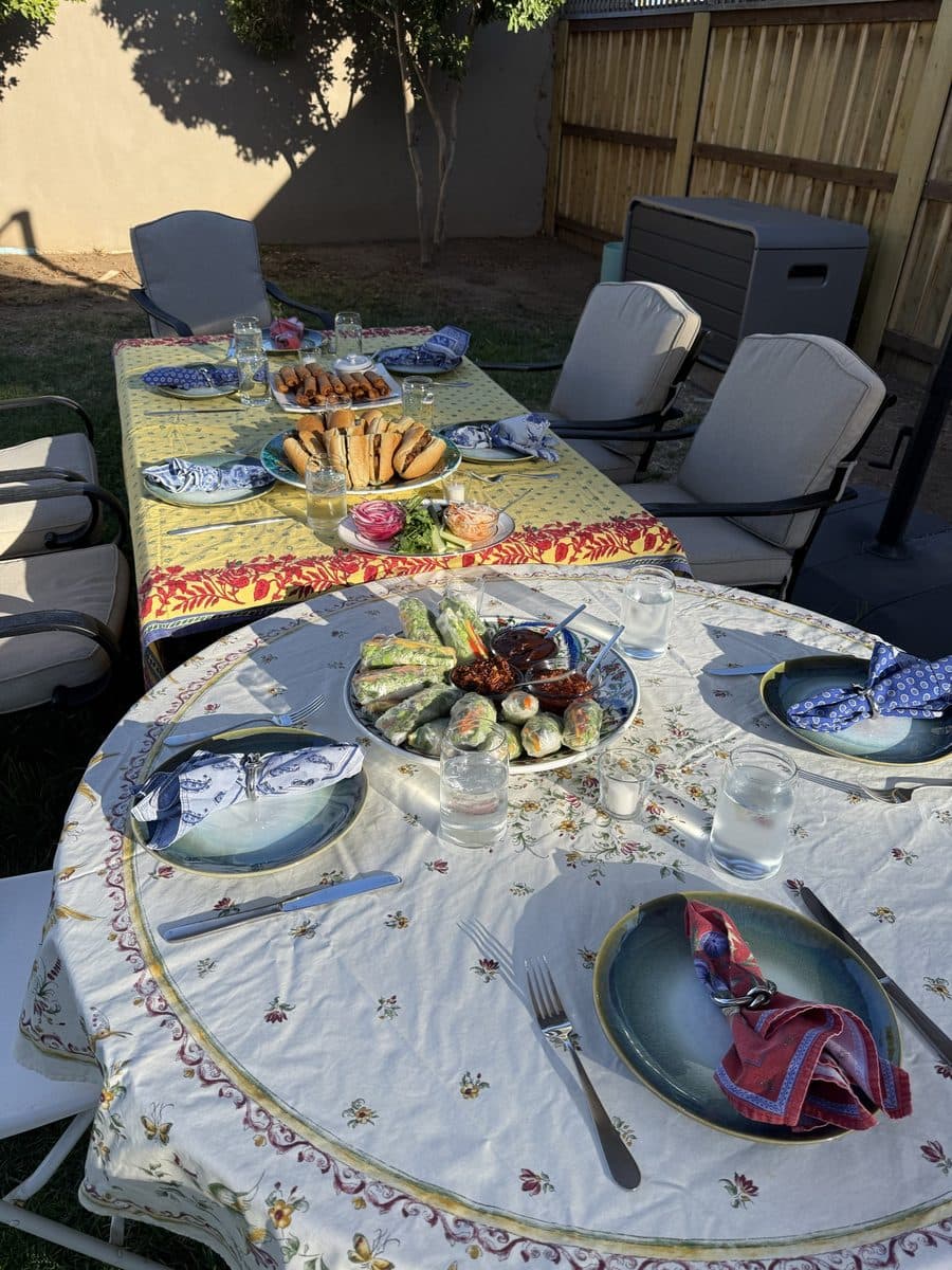 A table laid with place settings and platters for a dinner party at golden hour